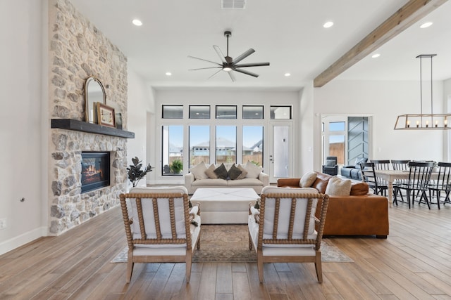 2019 Stargrass Rd, Haslet, TX 76052 - living room with a ceiling fan, light wood finished floors, healthy amount of natural light, a stone fireplace, and beam ceiling