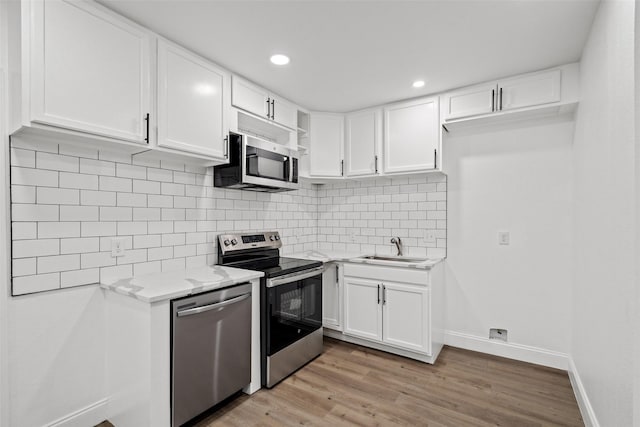 11832 Cromwell Dr, Dallas, TX 75234 - kitchen featuring stainless steel appliances, a sink, white cabinets, baseboards, and recessed lighting