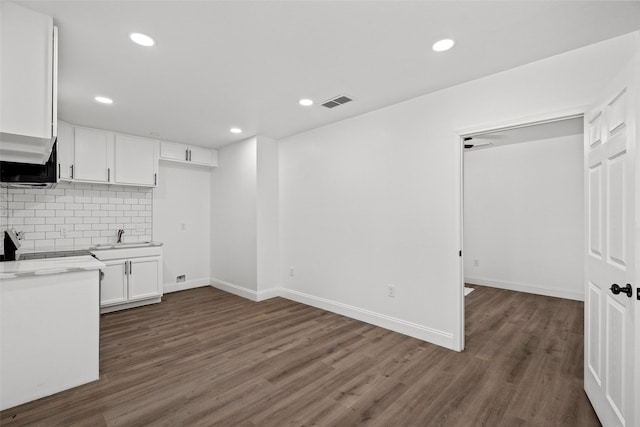 11832 Cromwell Dr, Dallas, TX 75234 - kitchen with white cabinets, a sink, tasteful backsplash, dark wood-style floors, and baseboards