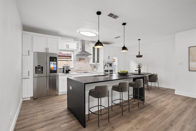 11832 Cromwell Dr, Dallas, TX 75234 - kitchen featuring stainless steel refrigerator with ice dispenser, wall chimney range hood, baseboards, and black electric cooktop