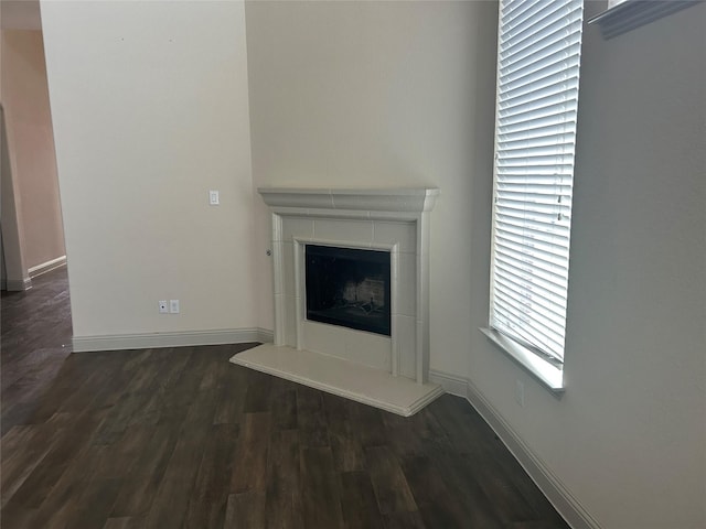1308 Carlet Dr, Little Elm, TX 75068 - unfurnished living room with dark wood-style flooring, a tiled fireplace, and baseboards