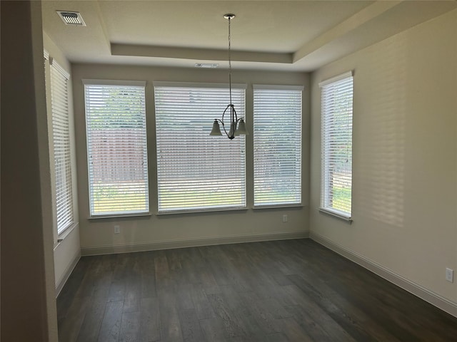1308 Carlet Dr, Little Elm, TX 75068 - unfurnished dining area with a tray ceiling, dark wood-style floors, baseboards, and a chandelier