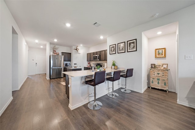 2212 Rosemary Way, Anna, TX 75409 - kitchen featuring stainless steel appliances, a kitchen bar, dark wood-style floors, a peninsula, and dark brown cabinets