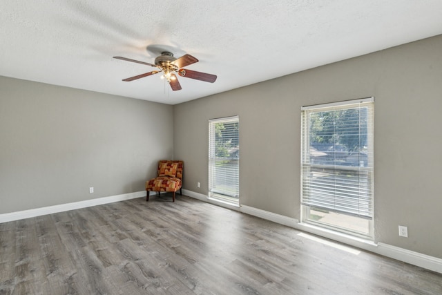 3233 Princess St, Bedford, TX 76021 - empty room featuring healthy amount of natural light, wood finished floors, ceiling fan, a textured ceiling, and baseboards