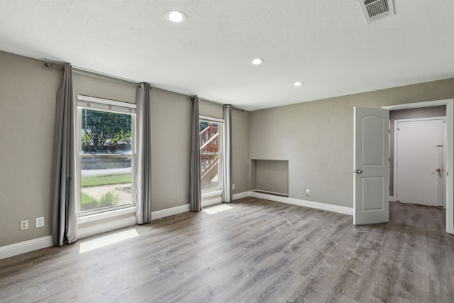 3233 Princess St, Bedford, TX 76021 - empty room featuring a textured ceiling, wood finished floors, recessed lighting, and baseboards