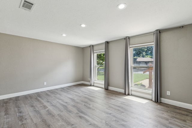 3233 Princess St, Bedford, TX 76021 - empty room featuring wood finished floors, recessed lighting, baseboards, and a textured ceiling