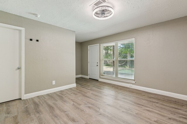 3233 Princess St, Bedford, TX 76021 - empty room featuring wood finished floors, a textured ceiling, baseboards, and a smoke detector