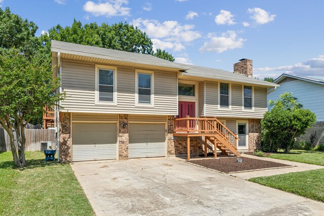 3233 Princess St, Bedford, TX 76021 - bi-level home with an attached garage, concrete driveway, brick siding, and a chimney