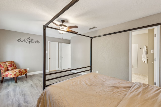 3233 Princess St, Bedford, TX 76021 - bedroom with light wood-style flooring, a textured ceiling, and ceiling fan