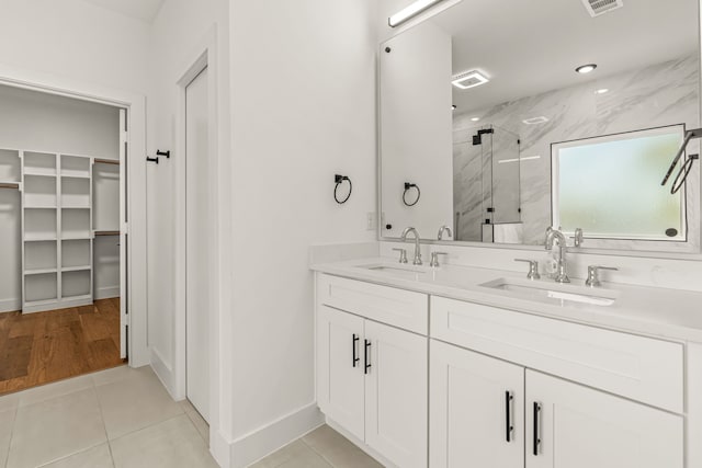 908 Muncie Ave, Dallas, TX 75212 - full bathroom with a marble finish shower, double vanity, a spacious closet, tile patterned floors, and baseboards