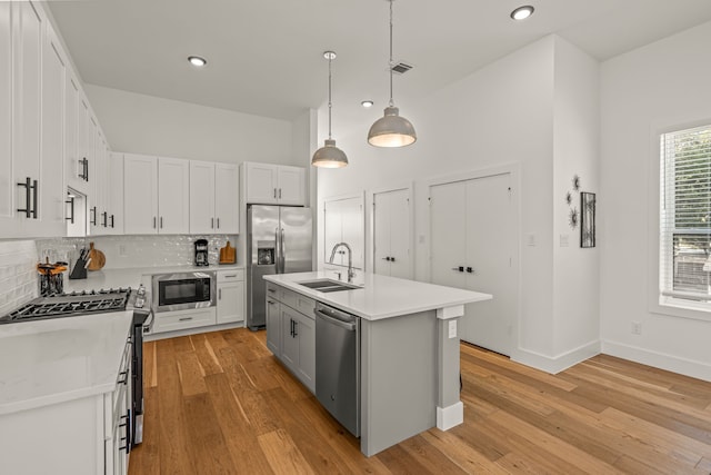 908 Muncie Ave, Dallas, TX 75212 - kitchen with a sink, stainless steel appliances, light countertops, tasteful backsplash, and light wood-style floors