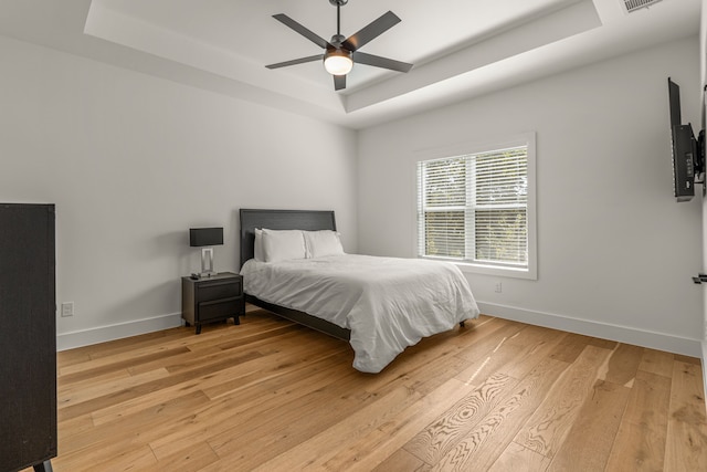 908 Muncie Ave, Dallas, TX 75212 - bedroom with a raised ceiling, light wood-style flooring, baseboards, and a ceiling fan