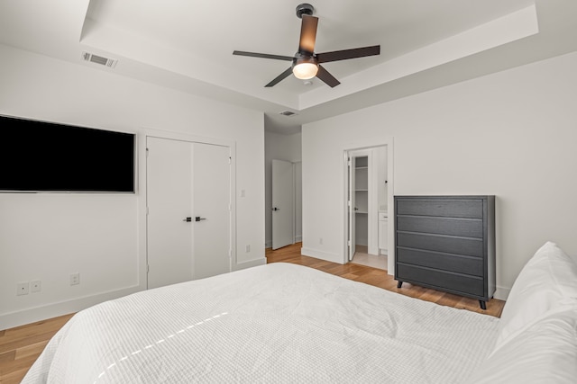 908 Muncie Ave, Dallas, TX 75212 - bedroom with a tray ceiling, a closet, and light wood-style floors