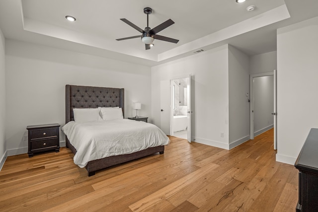 908 Muncie Ave, Dallas, TX 75212 - bedroom featuring a tray ceiling, recessed lighting, light wood-type flooring, baseboards, and ensuite bathroom