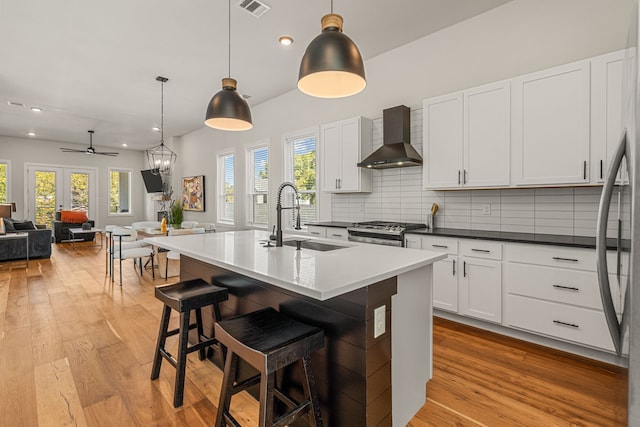 920 Muncie Ave, Dallas, TX 75212 - kitchen featuring wall chimney range hood, a sink, stainless steel range with gas cooktop, light wood-type flooring, and recessed lighting