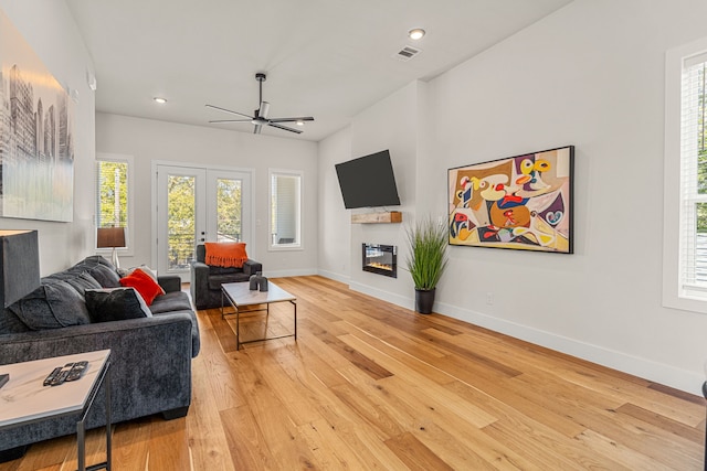 920 Muncie Ave, Dallas, TX 75212 - living area featuring ceiling fan, light wood-style flooring, a glass covered fireplace, baseboards, and french doors