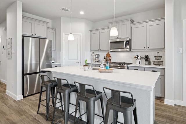 517 Big Horn Pass, Denton, TX 76210 - kitchen with appliances with stainless steel finishes, gray cabinetry, baseboards, wood finished floors, and recessed lighting