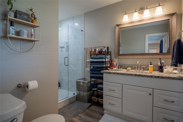 1306 S Oak Cliff Blvd, Dallas, TX 75208 - bathroom with toilet, vanity, wood finished floors, and a stall shower