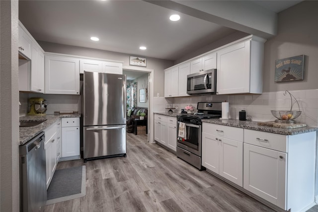 1306 S Oak Cliff Blvd, Dallas, TX 75208 - kitchen with stainless steel appliances, backsplash, white cabinets, stone countertops, and recessed lighting