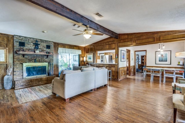 677 Fm 3356, Van Alstyne, TX 75495 - living room featuring wood walls, wood finished floors, a ceiling fan, a textured ceiling, and a fireplace