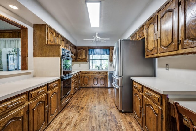 677 Fm 3356, Van Alstyne, TX 75495 - kitchen featuring stainless steel appliances, wood finished floors, light countertops, a ceiling fan, and a sink