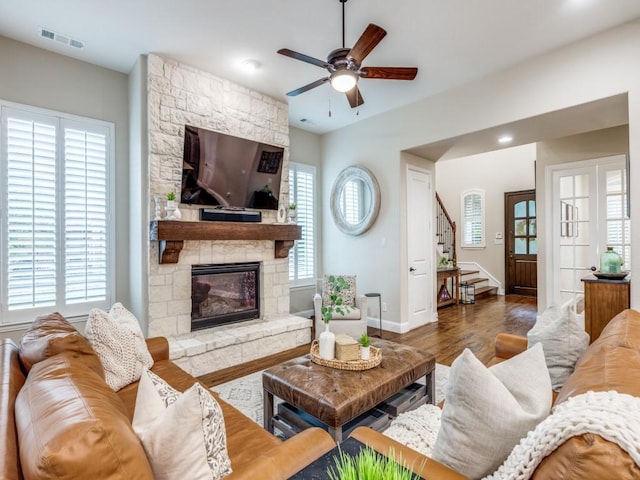5717 Dr Kenneth Cooper Dr, Mckinney, TX 75070 - living room with a ceiling fan, stairs, wood finished floors, a stone fireplace, and baseboards