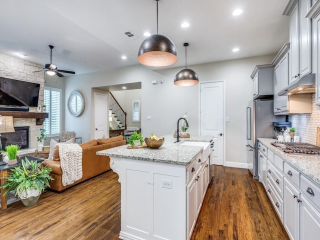 5717 Dr Kenneth Cooper Dr, Mckinney, TX 75070 - kitchen featuring open floor plan, appliances with stainless steel finishes, ceiling fan, under cabinet range hood, and a sink