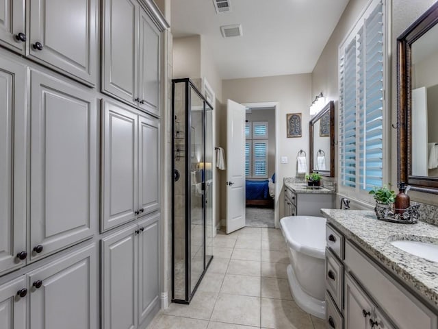 5717 Dr Kenneth Cooper Dr, Mckinney, TX 75070 - bathroom with a stall shower, two vanities, a soaking tub, and tile patterned floors