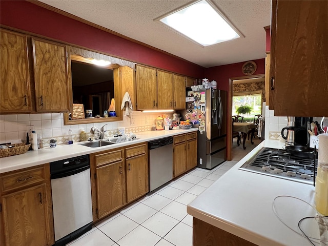 2101 Chase Bnd, Shreveport, LA 71118 - kitchen with appliances with stainless steel finishes, a sink, brown cabinetry, and decorative backsplash