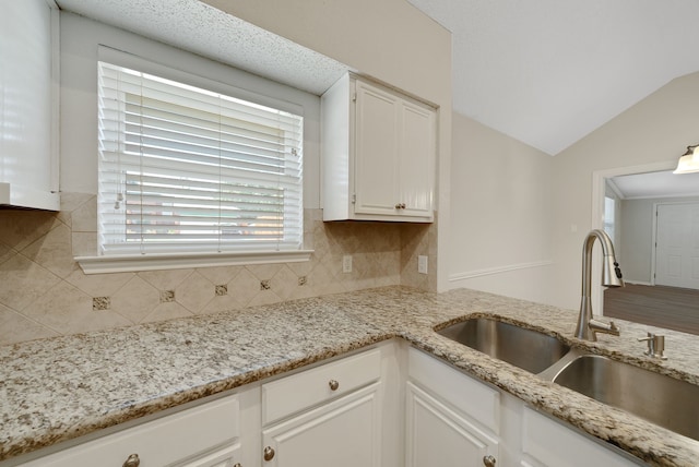736 Lionel Way, Fort Worth, TX 76108 - kitchen with a sink, decorative backsplash, white cabinetry, light stone counters, and lofted ceiling