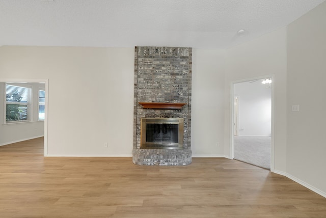 736 Lionel Way, Fort Worth, TX 76108 - unfurnished living room with light wood-style flooring, a large fireplace, and baseboards