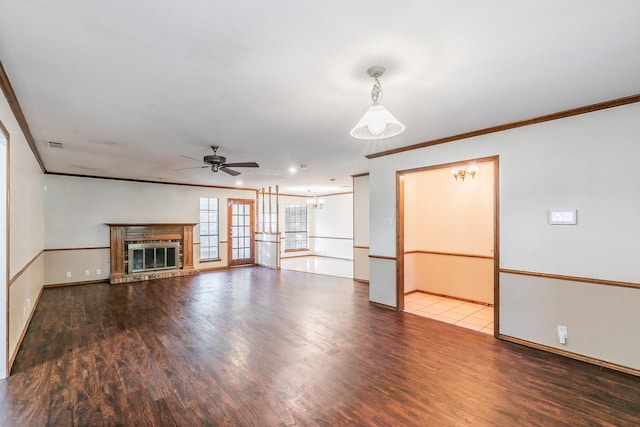1510 Surry Place Dr, Cleburne, TX 76033 - unfurnished living room featuring crown molding, a ceiling fan, wood finished floors, a fireplace, and a chandelier