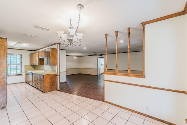 1510 Surry Place Dr, Cleburne, TX 76033 - kitchen featuring a chandelier, ceiling fan, dishwasher, light countertops, and brown cabinetry