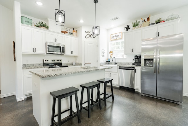 13530 Hiram Rd, Wills Point, TX 75169 - kitchen with stainless steel appliances, white cabinets, a kitchen bar, decorative light fixtures, and recessed lighting