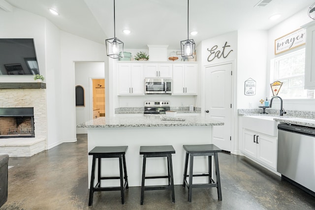 13530 Hiram Rd, Wills Point, TX 75169 - kitchen featuring appliances with stainless steel finishes, finished concrete flooring, white cabinets, a breakfast bar area, and recessed lighting