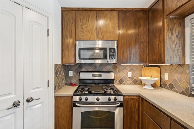 5020 Timber Creek Rd, Flower Mound, TX 75028 - kitchen with stainless steel appliances, light countertops, tasteful backsplash, and brown cabinets