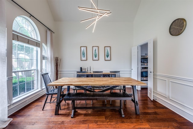 7905 Cherry Creek Dr, Plano, TX 75025 - dining space with high vaulted ceiling, a chandelier, a wainscoted wall, wood finished floors, and a decorative wall