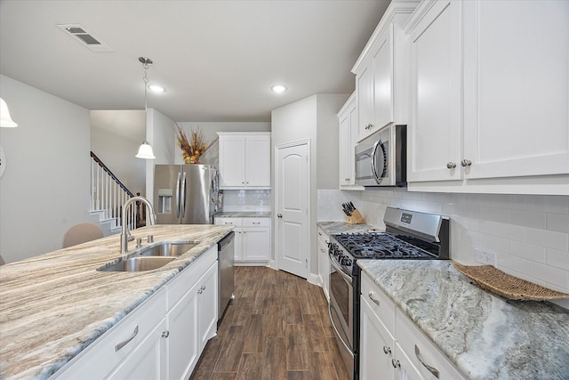 612 Redwood Dr, Greenville, TX 75402 - kitchen featuring appliances with stainless steel finishes, a sink, white cabinetry, tasteful backsplash, and recessed lighting