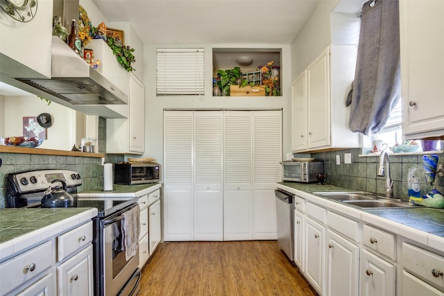 6980 Prather Rd, Springtown, TX 76082 - kitchen featuring stainless steel appliances, a sink, tile counters, and white cabinets