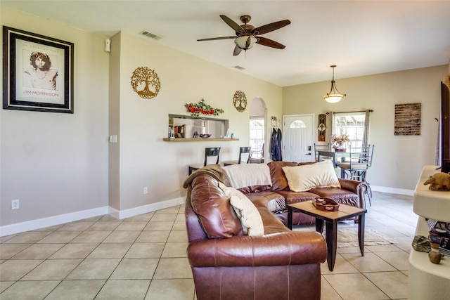 6980 Prather Rd, Springtown, TX 76082 - living room featuring light tile patterned flooring, arched walkways, a ceiling fan, and baseboards