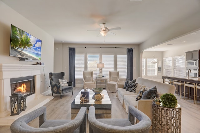 1305 Xeraco Dr, Little Elm, TX 75068 - living area featuring ceiling fan, light wood-type flooring, a fireplace, and healthy amount of natural light