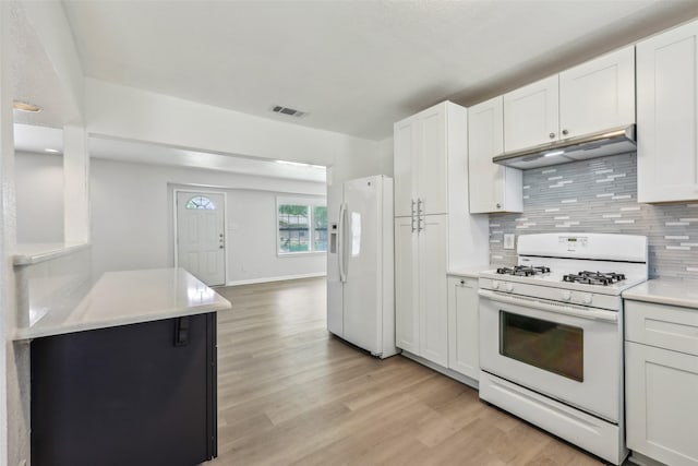 1320 Dale Dr, Garland, TX 75041 - kitchen with white appliances, under cabinet range hood, light wood-type flooring, tasteful backsplash, and light countertops