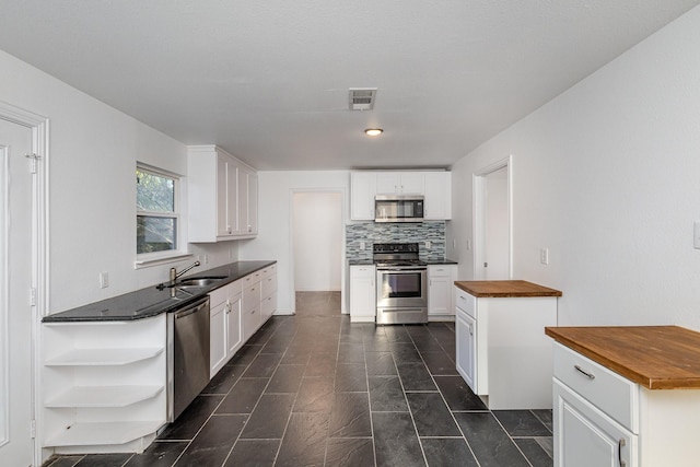 111 Leighton Dr, Terrell, TX 75160 - kitchen featuring appliances with stainless steel finishes, butcher block counters, open shelves, a sink, and white cabinets