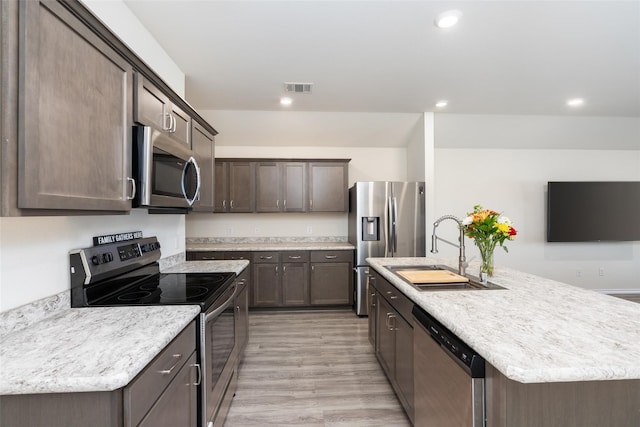 100 Samuel St, Denton, TX 76207 - kitchen featuring appliances with stainless steel finishes, a sink, dark brown cabinets, light countertops, and recessed lighting