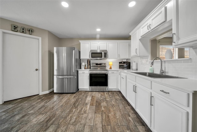 552 Lincoln Ave, Lavon, TX 75166 - kitchen with stainless steel appliances, a sink, white cabinetry, backsplash, and dark wood finished floors
