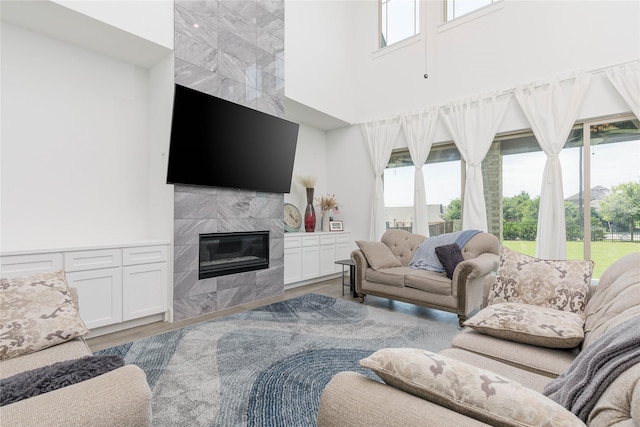 2130 Lassen Dr, Prosper, TX 75078 - living area featuring a towering ceiling, plenty of natural light, wood finished floors, and a premium fireplace