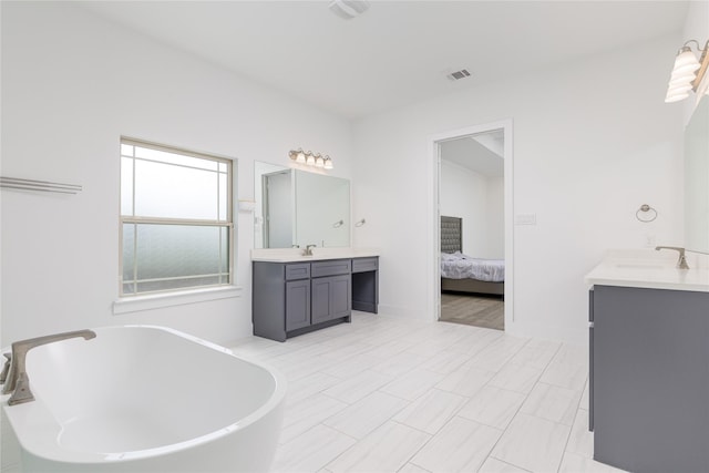 2130 Lassen Dr, Prosper, TX 75078 - bathroom featuring two vanities, a soaking tub, and ensuite bath
