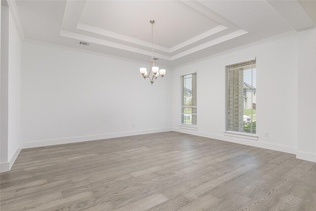 2130 Lassen Dr, Prosper, TX 75078 - empty room featuring a raised ceiling, a chandelier, light wood finished floors, and crown molding