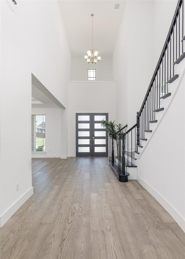 2130 Lassen Dr, Prosper, TX 75078 - foyer entrance featuring stairway, wood finished floors, a chandelier, a high ceiling, and baseboards