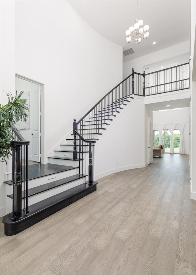 2130 Lassen Dr, Prosper, TX 75078 - staircase with a high ceiling, wood finished floors, a chandelier, baseboards, and recessed lighting
